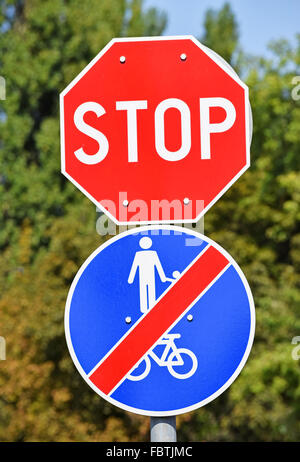Stop sign and end of bicycle road sign at the road crossing in the city Stock Photo
