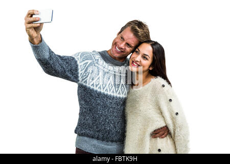 Cheerful young couple wearing warm clothing taking selfie Stock Photo