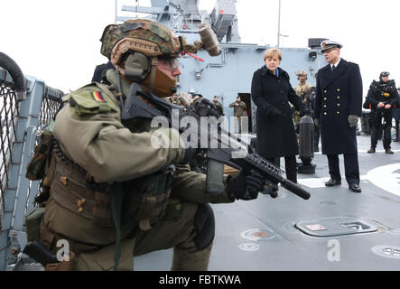 Kiel, Germany. 19th Jan, 2016. German Chancellor Angela Merkel watches a demonstration by frogmen, next to Captain Jan C. Kaack (r), on the deck of the corvette Braunschweig at the naval base in Kiel, Germany, 19 January 2016. Merkel will be briefed on the tasks and capabilities of the Flotilla 1 units during her visit. Photo: CHRISTIAN CHARISIUS/dpa/Alamy Live News Stock Photo