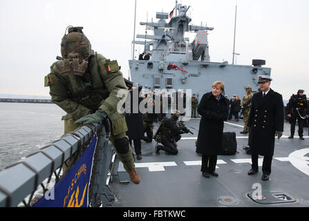 Kiel, Germany. 19th Jan, 2016. German Chancellor Angela Merkel watches a demonstration by frogmen, next to Captain Jan C. Kaack, on the deck of the corvette Braunschweig at the naval base in Kiel, Germany, 19 January 2016. Merkel will be briefed on the tasks and capabilities of the Flotilla 1 units during her visit. Photo: CHRISTIAN CHARISIUS/dpa/Alamy Live News Stock Photo