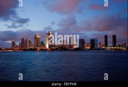 Sunset on San Diego skyline with city lights reflected in clouds taken from Coronado Stock Photo
