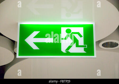 green emergency exit sign in a station Stock Photo