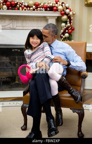U.S President Barack Obama snuggles with his niece Savita Ng after his sister, Maya Soetoro-Ng, and her family dropped by the Oval Office of the White House December 4, 2015 in Washington, DC.
