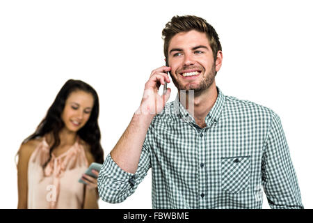 Smiling couple using cellphones Stock Photo