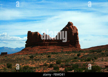 Courthouse Rock towers over the desert sands and scrubland at Arches National Park near Moab Utah, USA. Stock Photo
