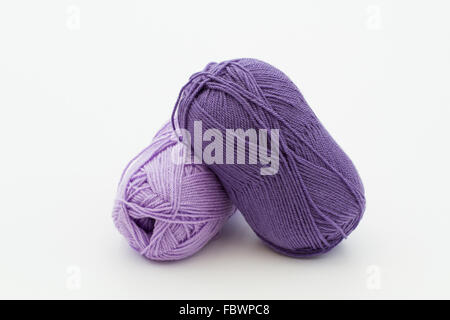 Two balls of wool in a purple color on an isolated white background. Stock Photo