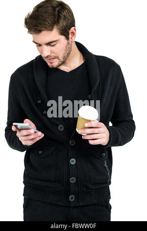 Handsome man using smartphone and holding disposable cup Stock Photo