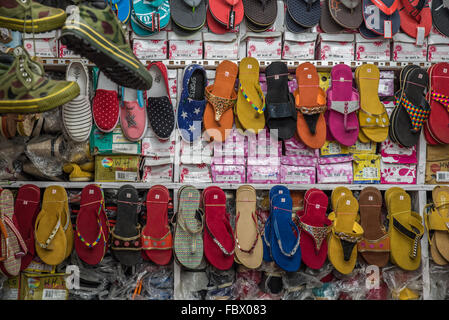 A wide variety of fashionable and vibrant footwear for sale on a market stall in Kohima Market. Stock Photo
