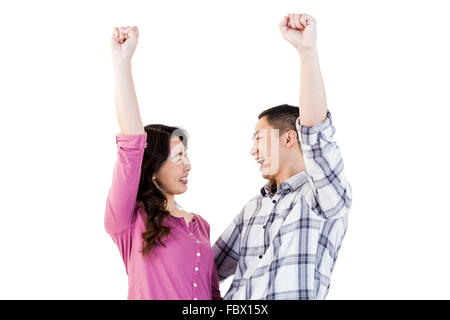 Cheerful young couple with hands raised Stock Photo