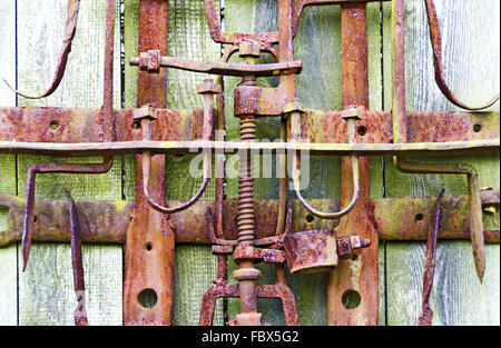 rusty iron machinery on old wooden wall Stock Photo