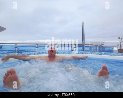Man grimacing in hot tub on cruise ship in ice field of Antarctica. Stock Photo