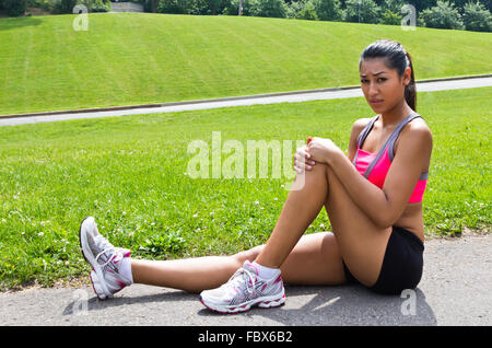 Young woman with running injury on knee Stock Photo