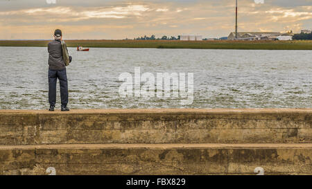 Back view of old tall caucasian man taking photos under the bridfe at Santa Lucia river which is located in the outsides of Mont Stock Photo