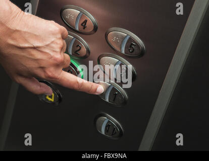 Hand is pressing the 1th floor Stock Photo