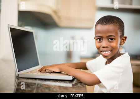 Smiling boy using laptop Stock Photo