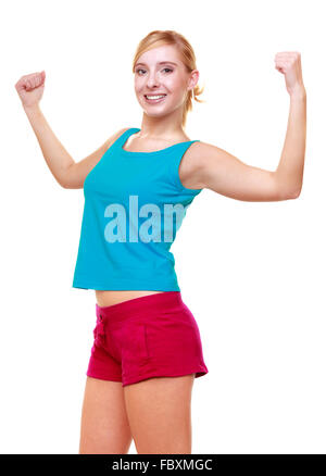 Physically fit woman wearing sports bra flexes arm muscles Stock