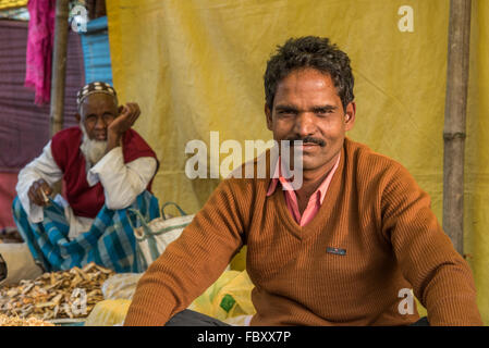 Indian market. Two seated male market traders selling assorted dried fish at the very large and very vibrant Balipara Saturday Market,  Assam, India. Stock Photo