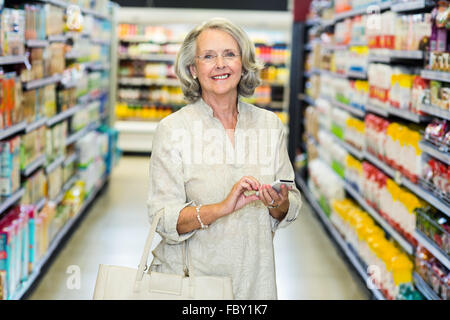 Smiling senior woman using smartphone Stock Photo