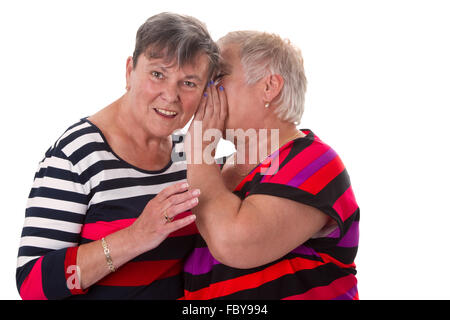 Two senior women whispering Stock Photo