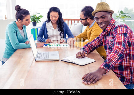 Portrait of business man sitting with colleagues in background Stock Photo