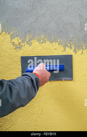 White facades painting with paint roller - hand applying Stock Photo