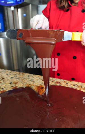 Food Sweets Chocolate making woman tempering chocolate on a cold marble table Stock Photo