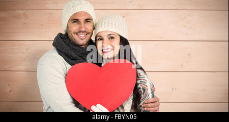 Composite image of smiling couple holding paper heart Stock Photo