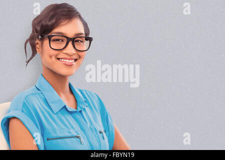 Composite image of portrait of smiling businesswoman wearing reading glasses Stock Photo
