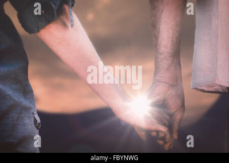 Composite image of couple holding hands in park Stock Photo