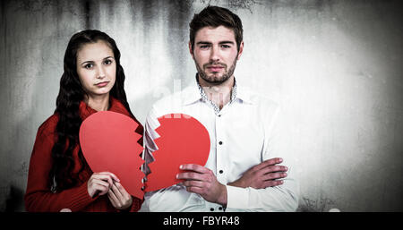 Composite image of couple holding heart halves Stock Photo