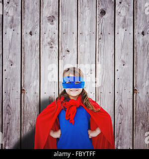 Composite image of masked girl pretending to be superhero Stock Photo