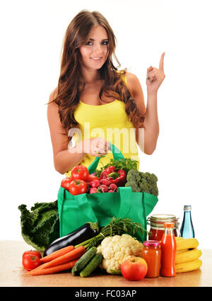 Young woman with variety of grocery products in shopping bag isolated on white Stock Photo