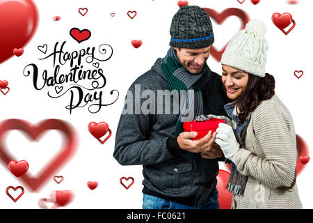 Composite image of festive couple exchanging a gift Stock Photo