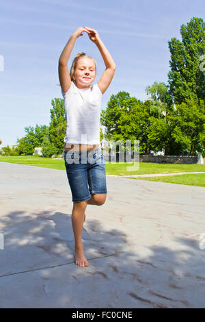 Cute girl jumping on one leg Stock Photo