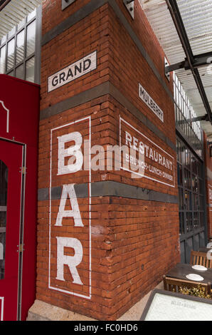 Painted bar sign on a red brick wall of Gelso and Grand bar and restaurant, corner of Grand and Mulberry street, Little Italy. Stock Photo