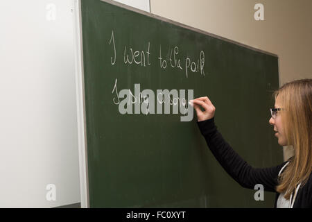 Student writes in english on the blackboard