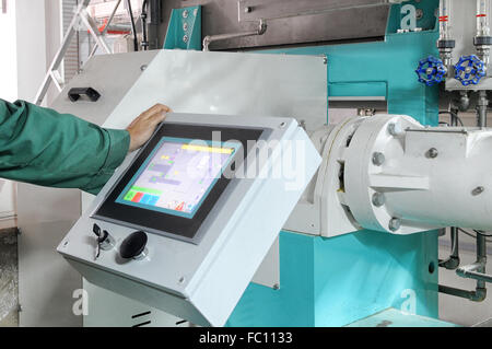 man operating factory machinery Stock Photo
