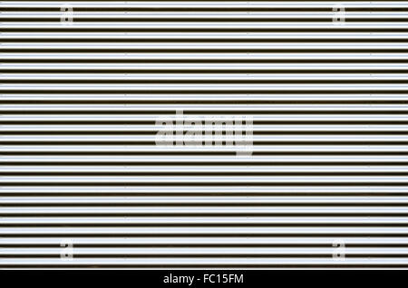 Background of shiny corrugated sheet metal with rivets for patterns and copy space Stock Photo