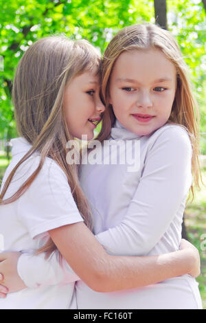 Smiling whispering girls in summer Stock Photo