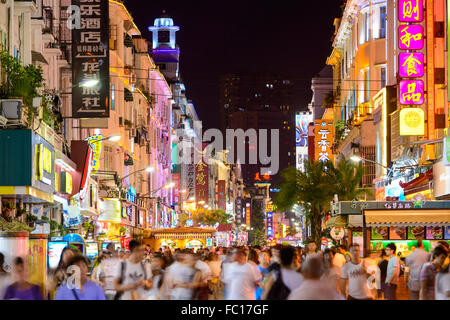 Pedestrians walk on Zhongshan Road at night in Xiamen, China. Stock Photo