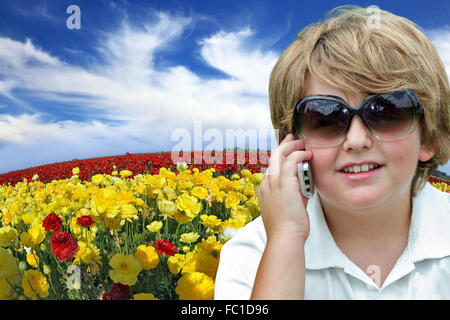 The blond boy talking on his mobile phone. Stock Photo