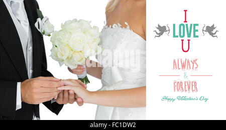 Composite image of young bridegroom putting on the wedding ring on his wifes finger Stock Photo