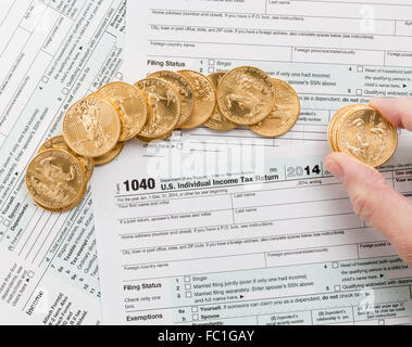 Solid gold coins on 2014 form 1040 Stock Photo