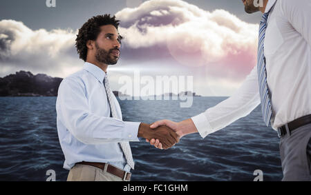 Composite image of young businessmen shaking hands in office Stock Photo