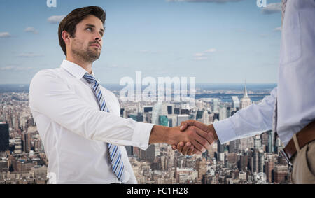 Composite image of two businessmen shaking hands in office Stock Photo