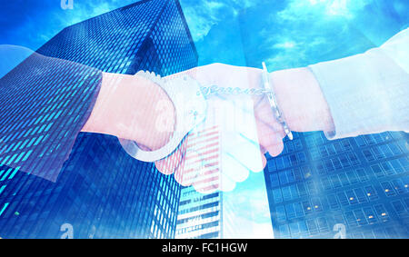 Composite image of business people in handcuffs shaking hands Stock Photo