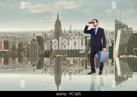 Composite image of businessman looking through binoculars holding briefcase Stock Photo