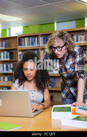 Student getting help from classmate in library Stock Photo