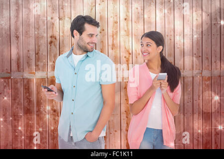 Composite image of happy couple sending text messages Stock Photo