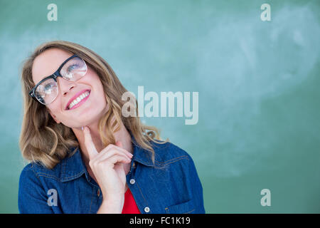 Smiling geeky teacher standing in front of blackboard Stock Photo